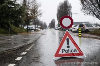 A police warning sign ahaed of a closed road after a shooting in Sion, Switzerland, Monday, December 11, 2023. According to the police of the canton of Valais. An individual fired several shots in Sion on Monday morning, at two separate locations. Two people died and another was injured. An individual fired several shots in Sion on Monday morning, at two separate locations. Two people died and another was injured. (KEYSTONE/Louis Dasselborne)